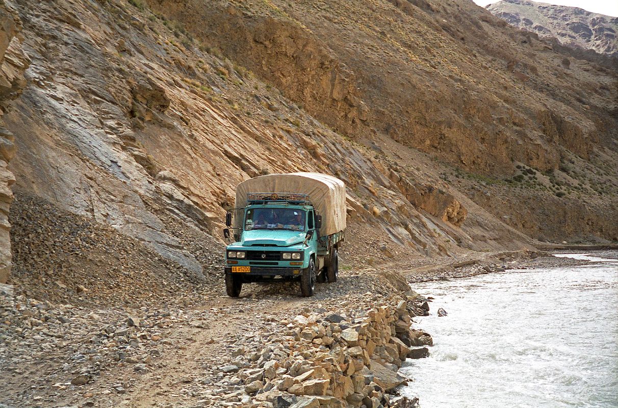 33 Truck Driving On Narrow Road Next To Chongphu Chu River On Drive To Kharta Tibet